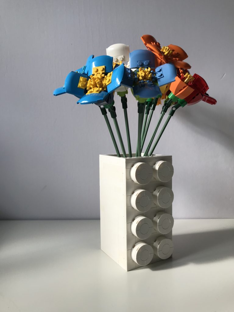 Colorful variations of LEGO's Poppy build from the Flower Bouquet set, in a white Brick Vase SEC by thebricknurse.