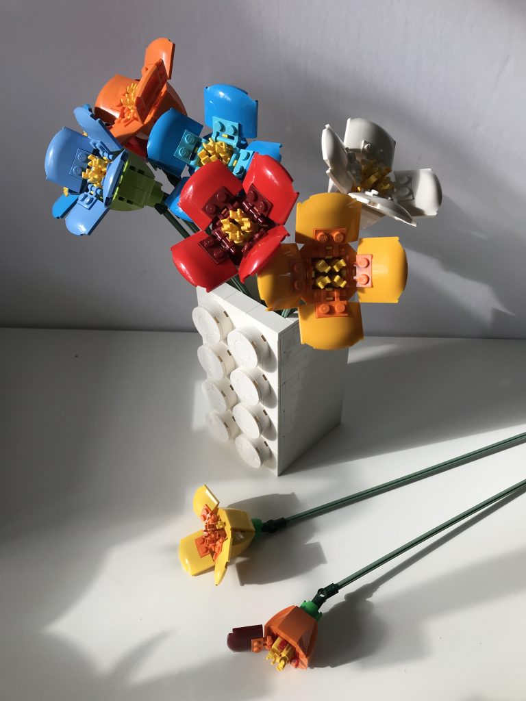 Colorful variations of LEGO's Poppy build from the Flower Bouquet set, in a white Brick Vase SEC by thebricknurse.