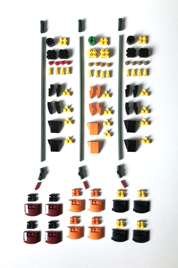 Unbuilt pieces of LEGO's poppy from the Flower Bouquet set in dark red, orange, and black and yellow are carefully arranged on a white table.